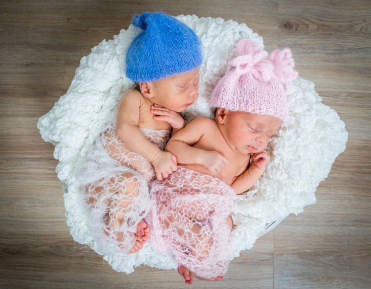 newborn twins - a boy and a girl sleeping in a basket