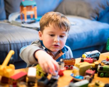 Child playing with Thomas and Friend trainset photo