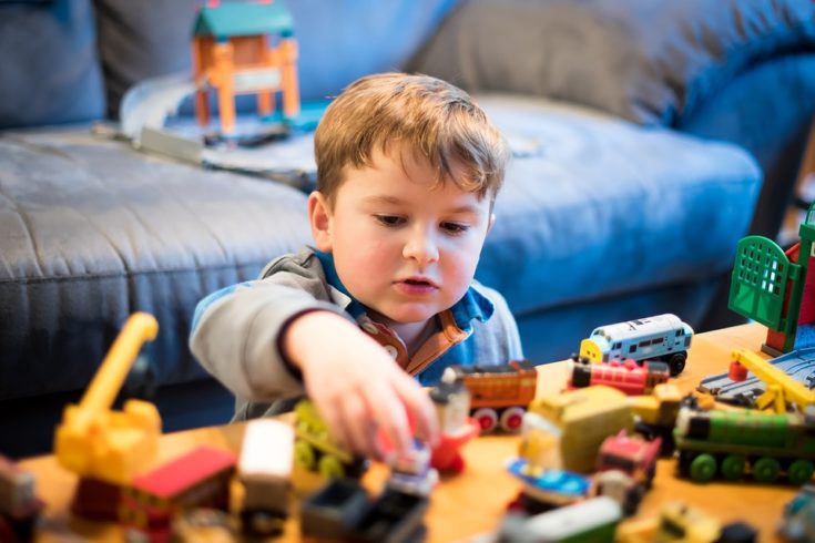 Child playing with Thomas and Friend trainset photo